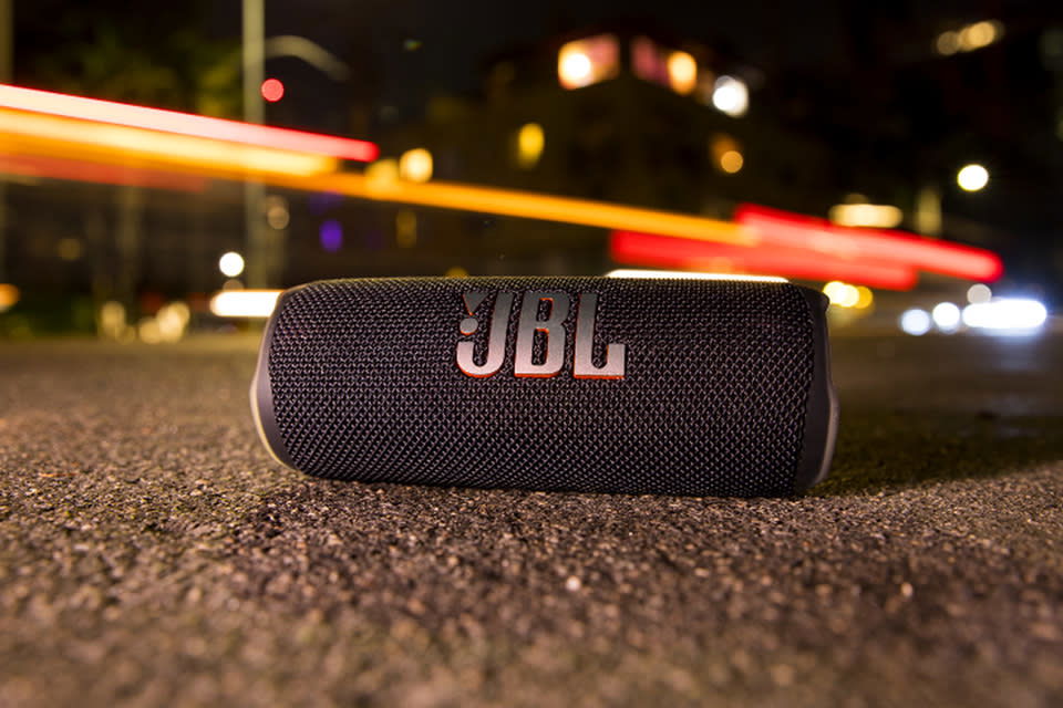 Το JBL Flip 6 κάθεται στο πεζοδρόμιο σε έναν δρόμο της πόλης τη νύχτα. 