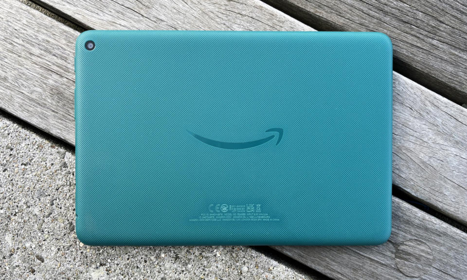 The Amazon Fire HD 8 tablet rests face down on a wood bench.