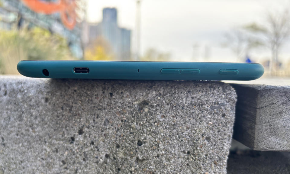 The top edge of the Amazon Fire HD 8 shown as the tablets rests atop a granite bench. 