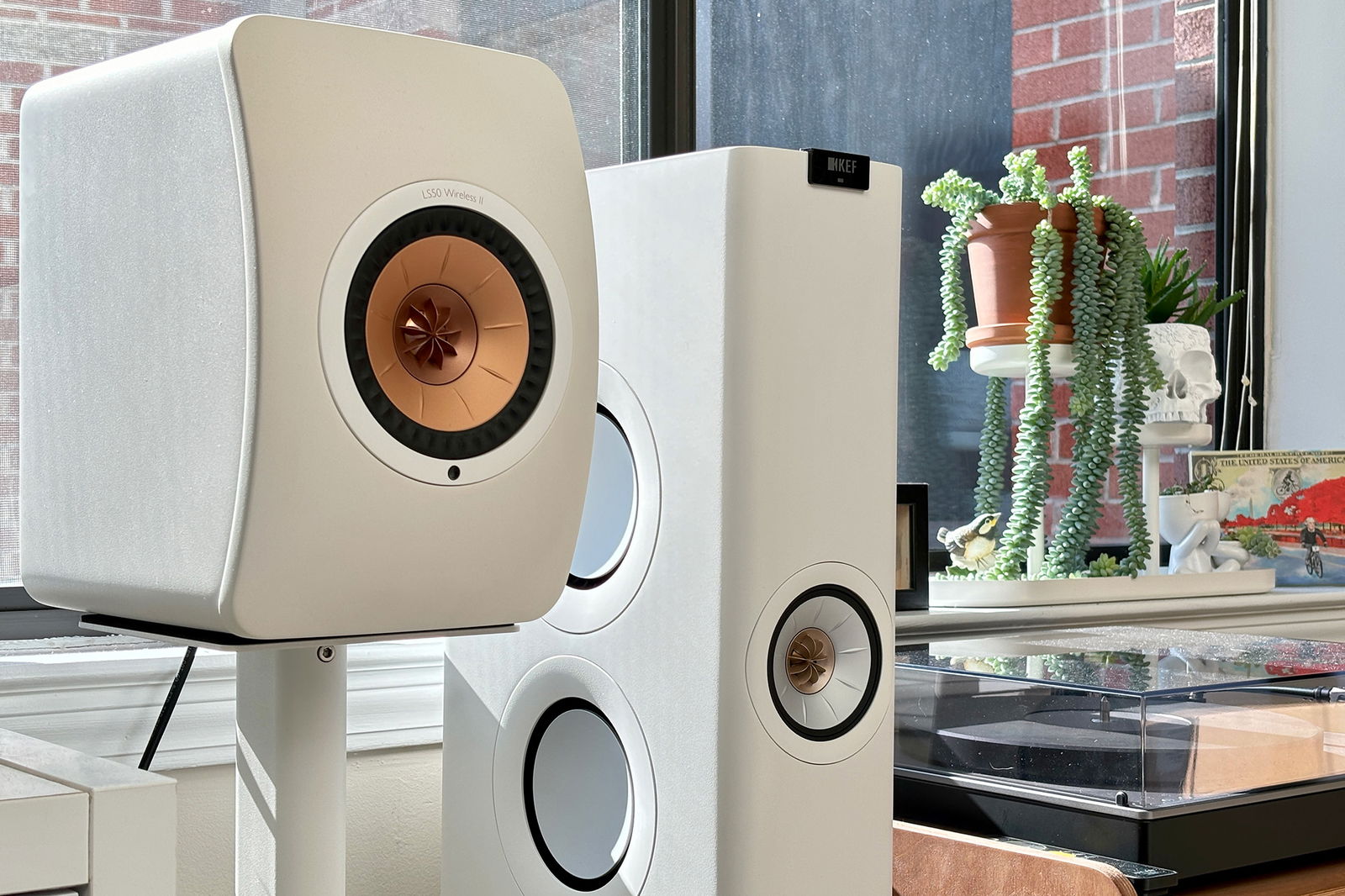 White KEF LS50 Wireless II standmount speakers and LS60 tower speakers next to a Cambridge Audio ALVA TT V2 turntable