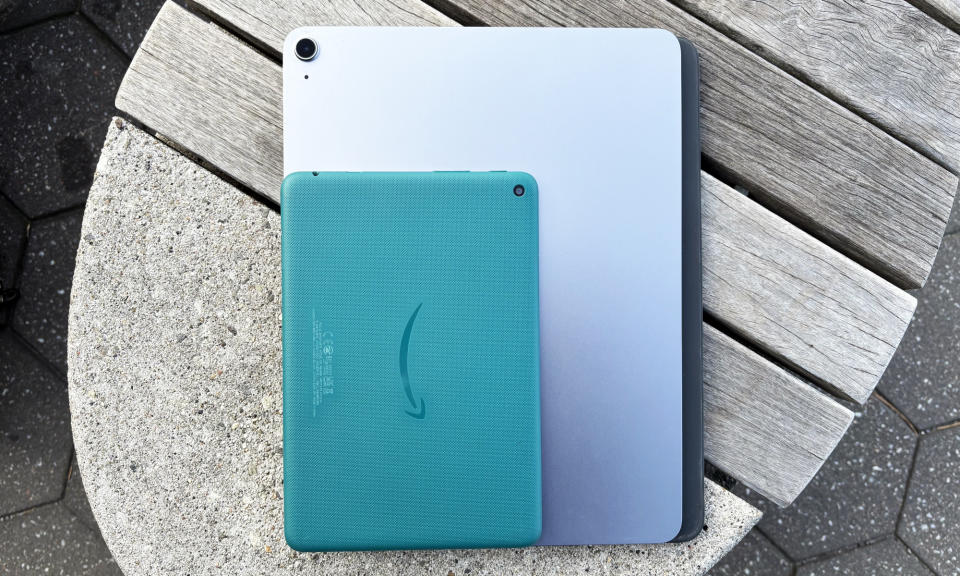 The Amazon Fire HD 8 tablet lays face down on top of a 13-inch Apple iPad Air.